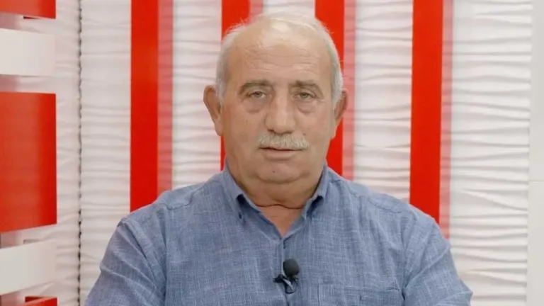 Topaloğlu konuşurken mikrofon önünde, arka planda toplantı veya basın ortamı bulanık görünüyor