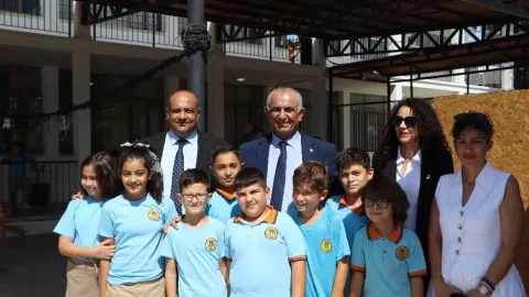 Çavuşoğlu okul ziyaretinde sınıf veya okul binası önünde bulunuyor