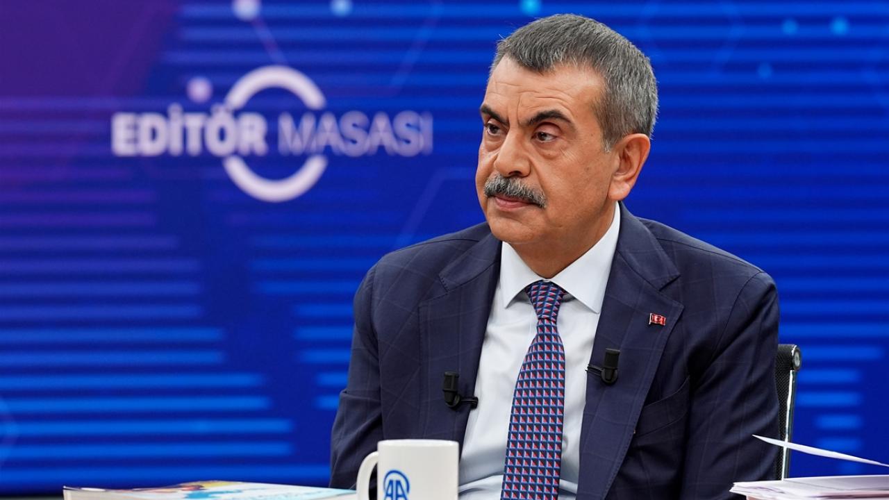 Bakan Tekin konuşurken kürsüde mikrofon ve arka planda PISA görseli