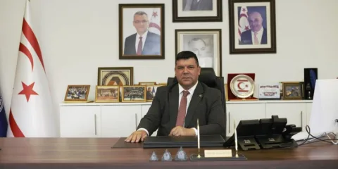 Prof. Dr. Hasan Kılıç konuşurken mikrofon önünde görünür.