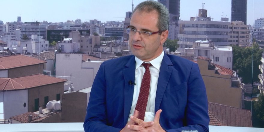 Menelau konuşurken mikrofon önünde, Kıbrıs sorununa ilişkin görüş belirtiyor