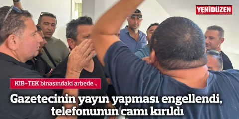 Gösteri sırasında bir kişinin telefonunun camı kırılmış halde tutuluyor, etrafta kalabalık ve hareket var