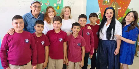 Sanatçılar ve öğrenciler Karpaz'da birlikte resim yaparken masa ve tuvallere odaklanmış durumda
