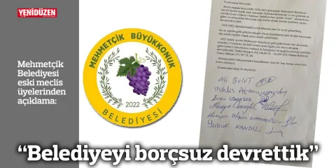 Belediye yetkilileri el sıkışırken belediye binası ve Türk bayrağı görünür.