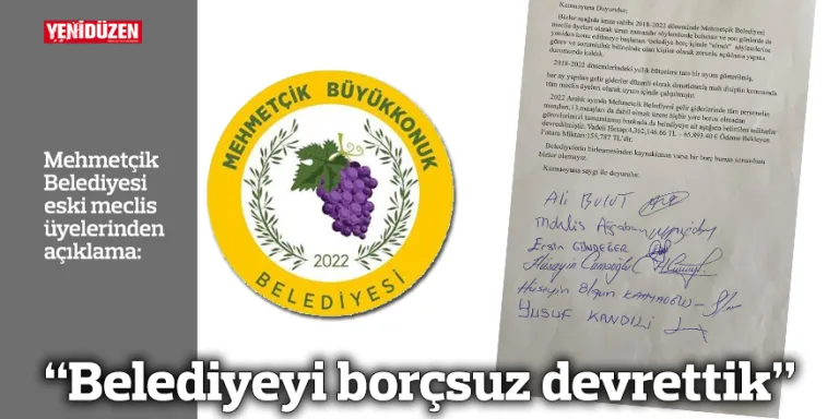 Belediye yetkilileri el sıkışırken belediye binası ve Türk bayrağı görünür.