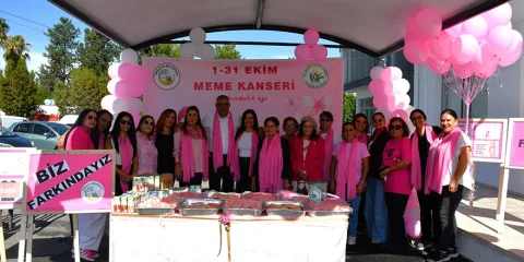 Mesarya'da meme kanseri farkındalığı etkinliğine katılanlar bilgilendirici pankartlar ve pembe sembollerle bir arada