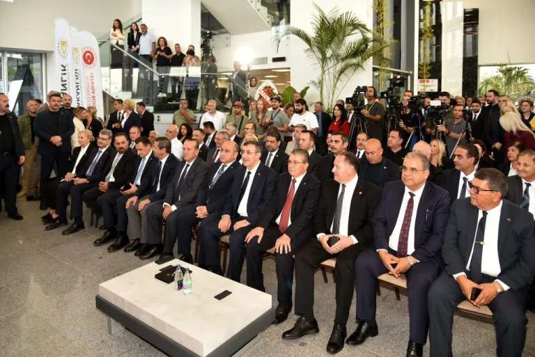 Dinçyürek konuşurken mikrofon ve arka planda parti logosu görünür