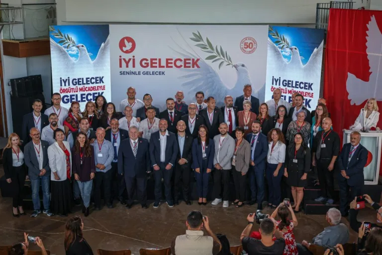 Çeler konuşurken mikrofon önünde, arka planda TDP logosu ve toplantı atmosferi
