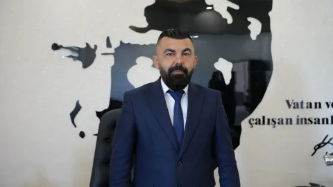 Kasım konuşma yaparken, muhtarlarla yerel yönetim iş birliği temasına vurgu edilen bir toplantı görüntüsü