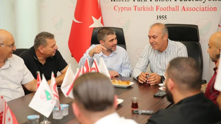 Aktunç konuşurken mikrofonla gazetecilere bakıyor