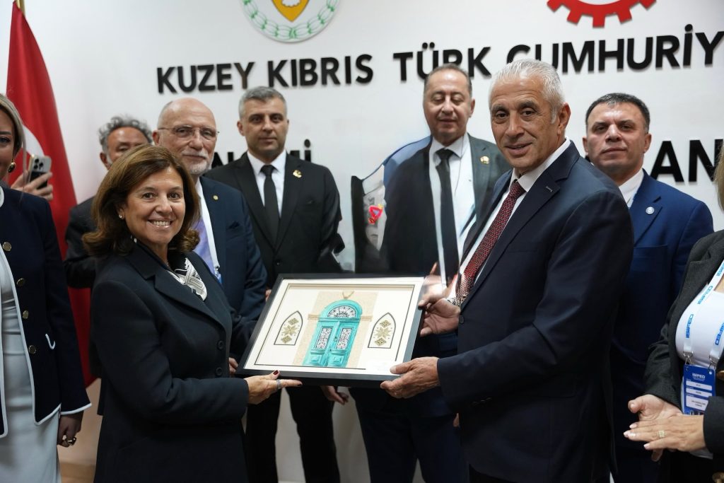 Taçoy, İSİFED heyetiyle resmi görüşmede yan yana otururken konuşuyor