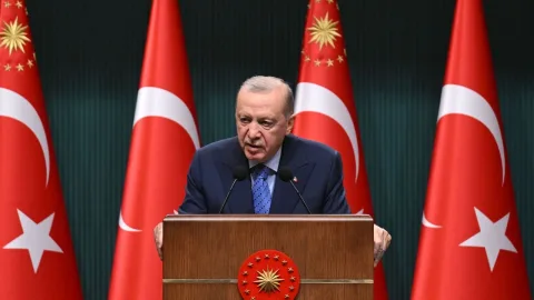 Cumhurbaşkanı Erdoğan konuşma yaparken kürsü ve Türk bayrağı arka planda