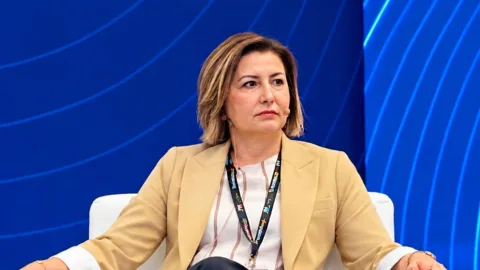 Hande Tibuk basın açıklaması yaparken konuşuyor, arka planda KKTC turizmi ve THY yazılı görsel öğeler