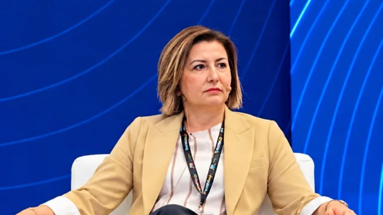 Hande Tibuk basın açıklaması yaparken konuşuyor, arka planda KKTC turizmi ve THY yazılı görsel öğeler