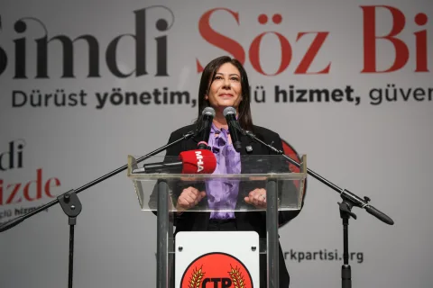 İncirli konuşma yaparken kalabalığa bakıyor, arka planda CTP pankartı ve destekçiler