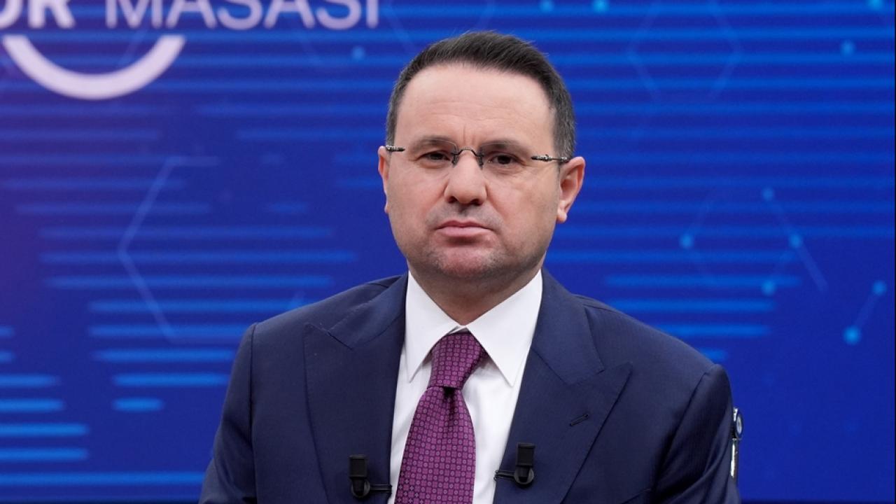 Bakan Gürlek konuşurken mikrofon ve kürsü önünde resmi görünüm