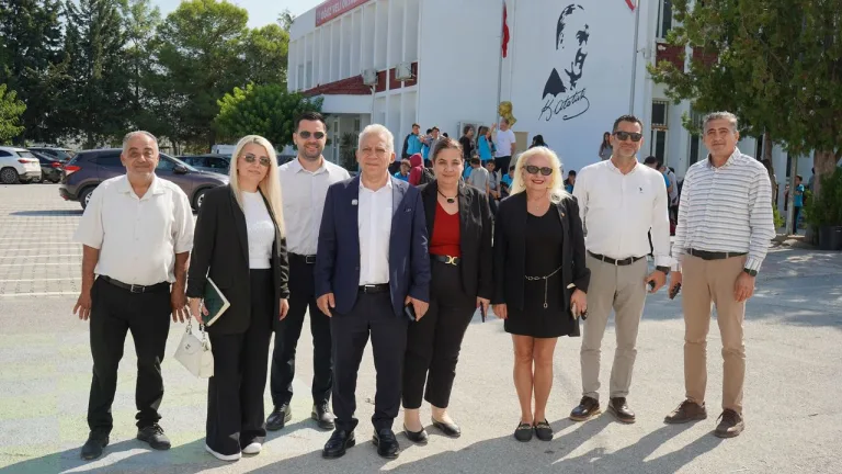 Dr. Paşaoğlu kürsüde konuşuyor; dinleyen sağlık ve eğitim çalışanları omuzları görünür