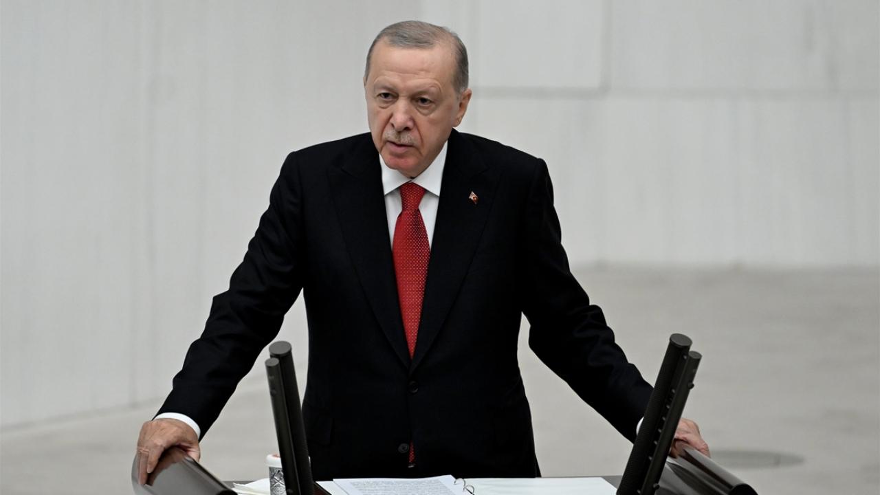 Cumhurbaşkanı Erdoğan canlı konuşma yaparken konuşma kürsüsünde mikrofonlara bakıyor