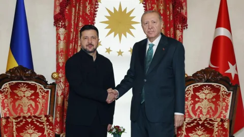 Cumhurbaşkanı Erdoğan kürsüde konuşurken, arka planda Türk bayrağı ve resmi ortam görünümü