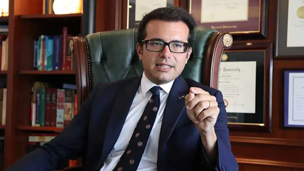 Murat Metin konuşurken mikrofon önünde, haber röportajı ortamı