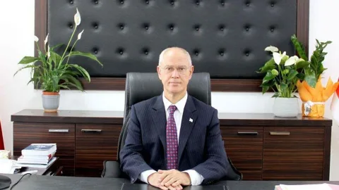 Oğuzhan Hasipoğlu konuşurken mikrofon ve arka planda destekçileriyle birlikte