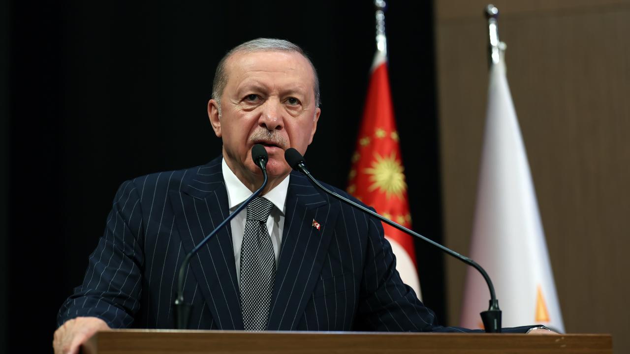 Cumhurbaşkanı Erdoğan konuşma yaparken mikrofon önünde, konuşma sırasında ifadeli bir görüntü