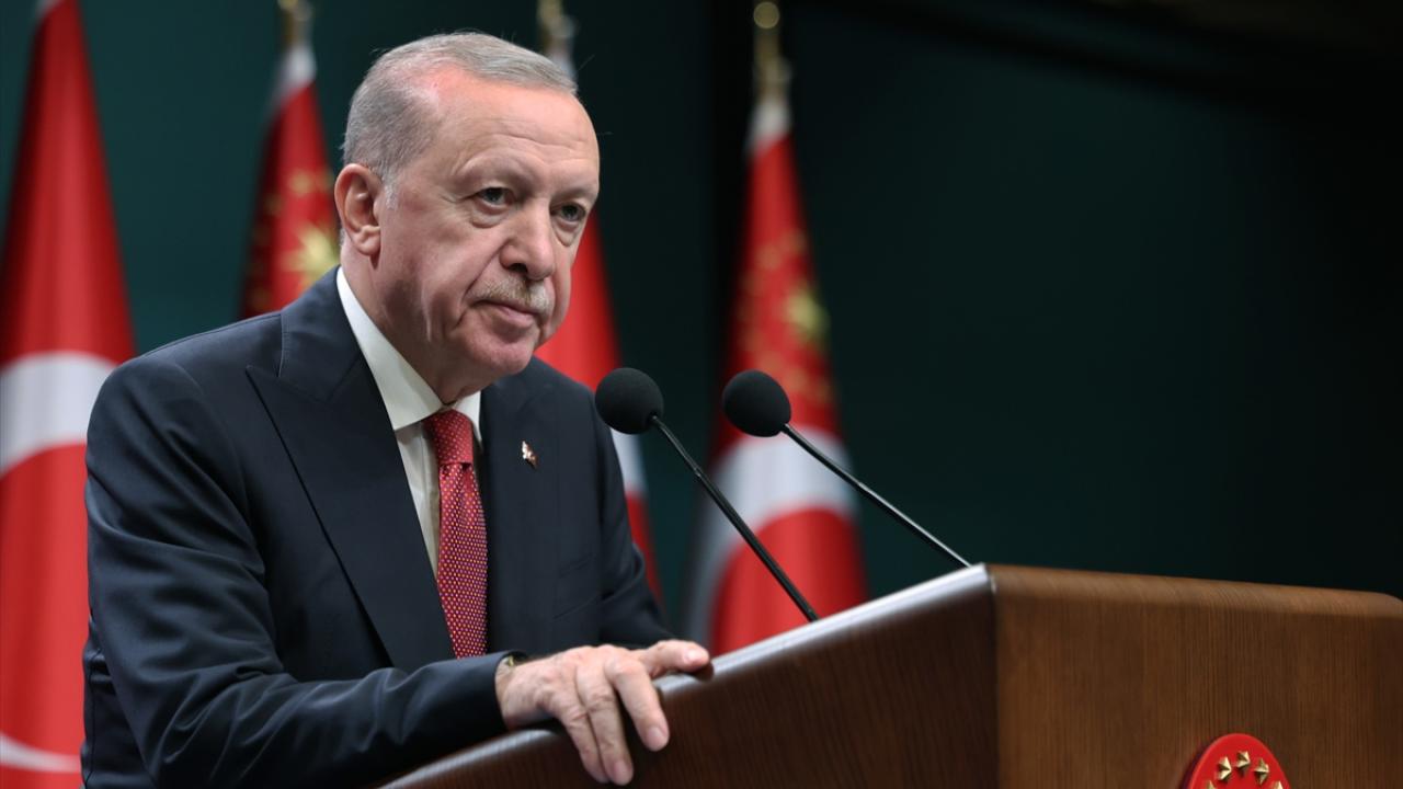 Erdoğan konuşurken mikrofonlara bakıyor ve ceketli halde konuşma yapıyor