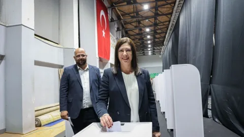 CTP örgütü içinde konuşan iki kişi, oy kullanma işlemi için sandık başında duruyor