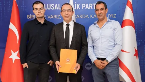 UBP Lefke aday adayı Aksu konuşma yaparken mikrofona bakıyor