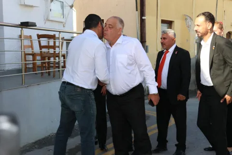 UBP Çatalköy-Esentepe adayı Albayrak konuşma yaparken mikrofon tutuyor ve kalabalığa bakıyor