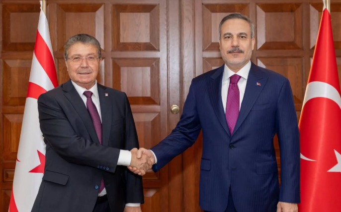 Üstel ve Yılmaz sokak veya ofis ortamında görüşürken, yan yana duruyor veya oturuyorlar